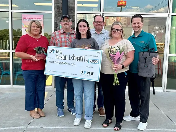 Leslie Hardin receiving a DYNE Scholarship check